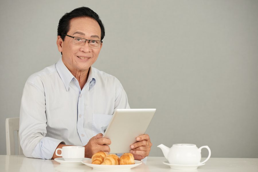 An elderly man answering an online survey